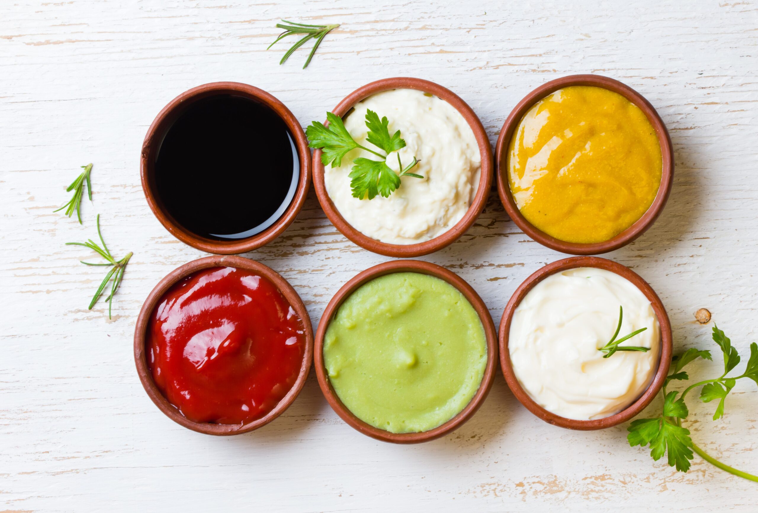 Sauces ketchup, mustar, mayonnaise, wasabi, soy sauce in clay bowls